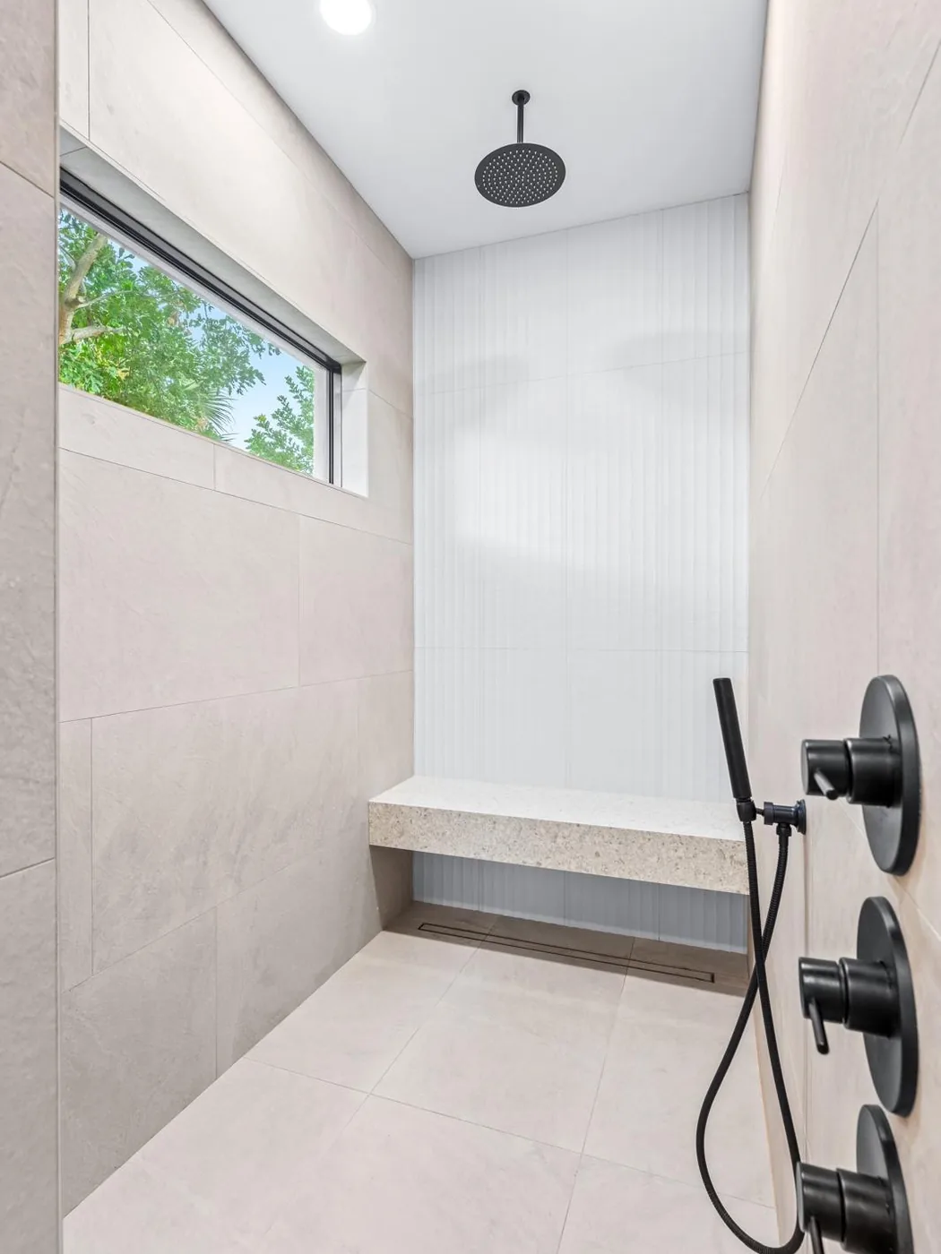 Large-format walk-in shower with bench
